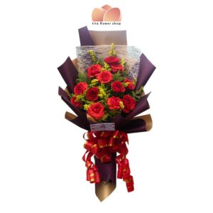 A hand-tied bouquet consisting of 12 red roses wrapped in a purple wrap