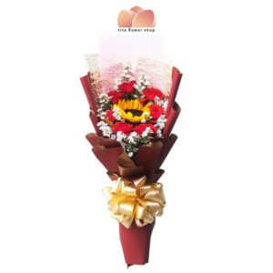 A hand-tied bouquet consisting of 7 red roses with 1 sunflower wrapped in a marron flower wrapper